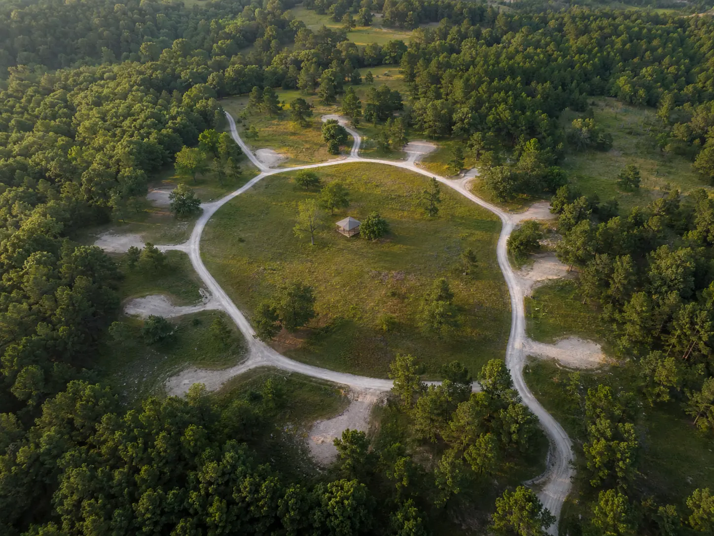 Aerial view of H Mountain Retreat with a gravel loop and wooded campsites